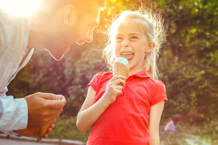 Father and daughter outdoors time together eating ice cream